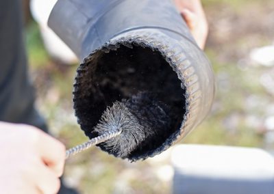 Man cleaning chimney pipe outside. Chimney sweep cleaning